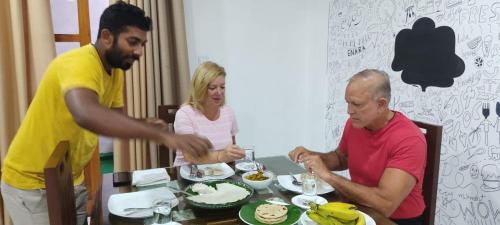 a group of people sitting around a table eating cake at Enara Luxury Stay in Katugastota