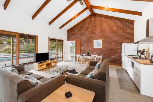 ein Wohnzimmer mit einem Sofa und einem Tisch in der Unterkunft A home amongst the gum trees in Torquay