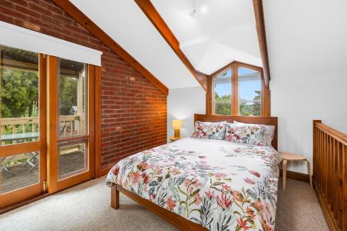 um quarto com uma cama e uma parede de tijolos em A home amongst the gum trees em Torquay