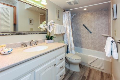 y baño con lavabo, aseo y espejo. en Ocean View Escape, Steps to Beach & Free Parking!, en Honolulu