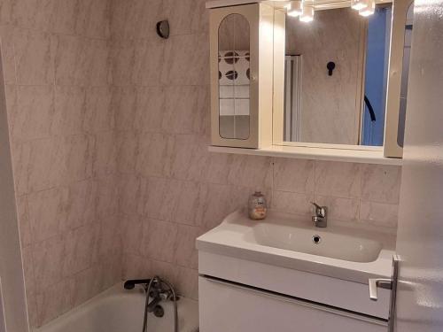 ein Badezimmer mit einem Waschbecken, einem Spiegel und einer Badewanne in der Unterkunft Appartement Cap d'Agde, 3 pièces, 6 personnes - FR-1-607-155 in Cap d'Agde