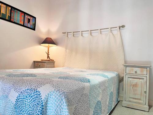 - une chambre dotée d'un lit avec une couverture bleue et blanche dans l'établissement Appartement Le Lavandou, 1 pièce, 4 personnes - FR-1-251-491, au Lavandou