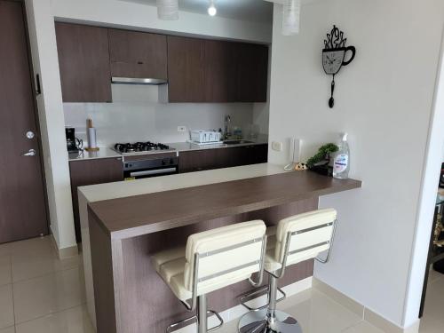 uma cozinha com um balcão e dois bancos em Hermoso apartamento para estrenar en Valle de Lili em Nariño