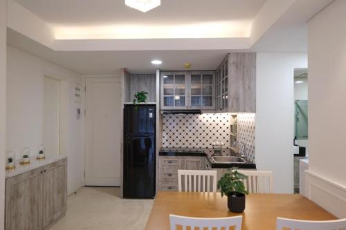 a kitchen with a black refrigerator and a table at New! Luxury Landmark Residence Apartment 2+1BR 96m in Bandung