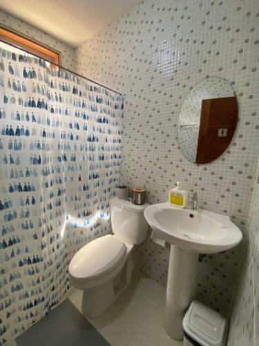 a bathroom with a toilet and a sink at MyGuide Travellers Inn in Coron