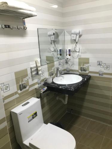 a bathroom with a toilet and a sink at Sea Balcony Hotel in Cat Ba