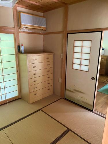 Cette chambre comprend une armoire et une porte. dans l'établissement 花緑里-Hanamidori-菅田ほたるの里 岐阜下呂関田園里山リゾート, à Gujō