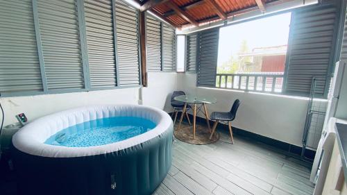 a large bath tub in a room with a table at Cosy suite centre ville avec bain à remous in Pointe-à-Pitre