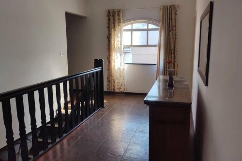um corredor com uma escada e uma janela numa casa em A Casa para a sua Família em Iguaba Grande, até 9 pessoas em Iguaba Grande