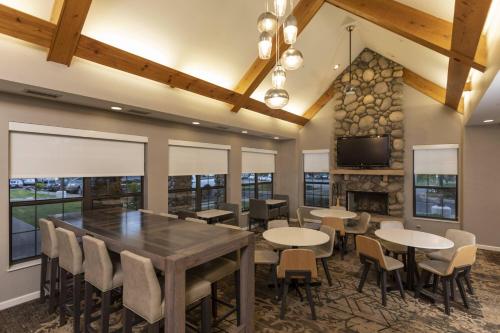 uma sala de jantar com mesas e cadeiras e uma lareira em Residence Inn Durango Downtown em Durango