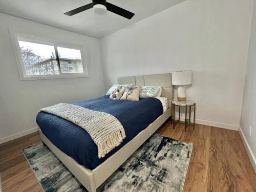 a bedroom with a bed and a ceiling fan at Central Penticton. Alongside KVR Trail. Freshly Renovated. Pet Friendly. in Penticton