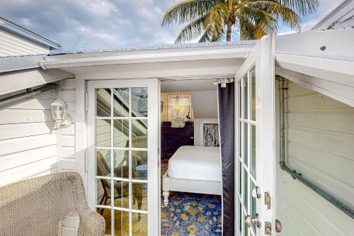 uma porta que leva a um quarto com uma cama em Seagrass Suite em Key West