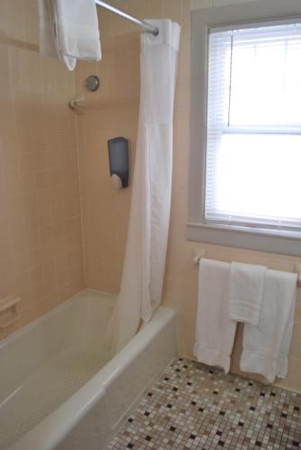 a bathroom with a tub and a shower with a window at Lankford Hotel and Lodge in Ocean City