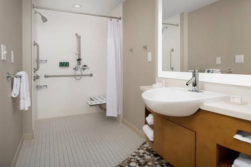 a white bathroom with a sink and a shower at Springhill Suites by Marriott Jackson North/Ridgeland in Ridgeland