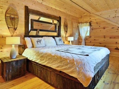 1 dormitorio con 1 cama en una cabaña de madera en BIGFOOT - Chalets de Môh - Jacuzzi, en La Malbaie