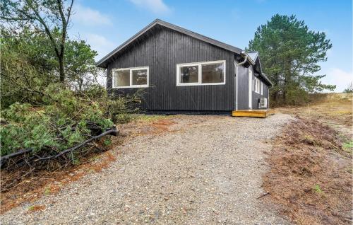 a black tiny house on a gravel road at 4 Bedroom Stunning Home In Ribe in Ribe