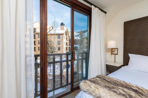 a bedroom with a bed and a large window at Beaver Creek Lodge, Autograph Collection in Beaver Creek