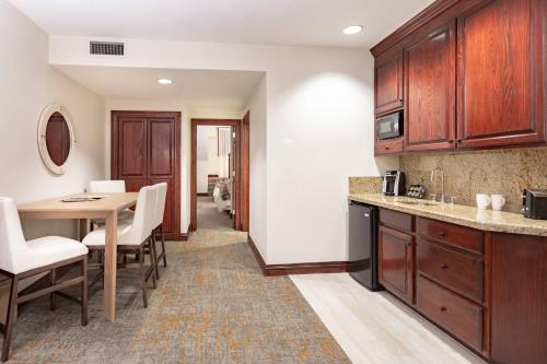a kitchen with wooden cabinets and a table and chairs at Beaver Creek Lodge, Autograph Collection in Beaver Creek