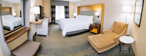 a hotel room with two beds and a mirror at Holiday Inn Hotel & Suites Stockbridge-Atlanta I-75, an IHG Hotel in Stockbridge