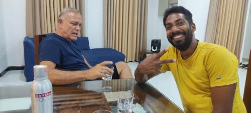 two men sitting in a living room with a table at Enara Luxury Stay in Katugastota