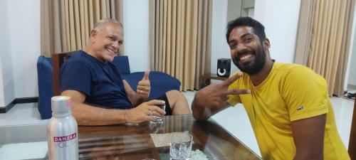 two men sitting at a table giving thumbs up at Enara Luxury Stay in Katugastota