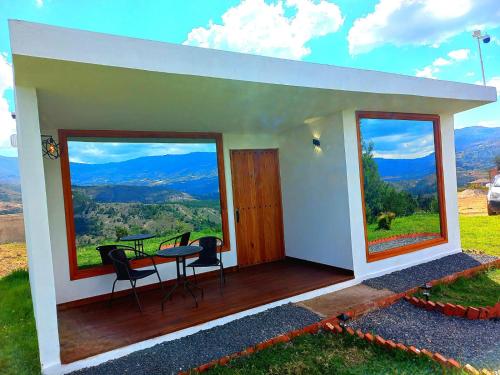 a house with a balcony with a table and chairs at Bajo las estrellas deluxe in Ráquira