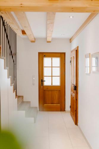 a hallway with a wooden door and stairs at Seehotel Berau in St. Wolfgang