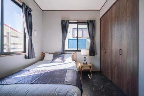 um quarto com uma cama grande e uma janela em プライベートハウス ぅーじ家 em Hanagusuku
