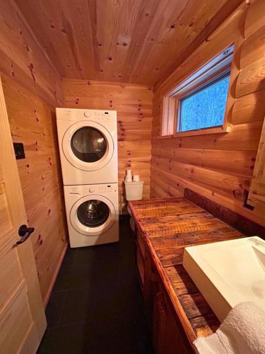 uma casa de banho com uma máquina de lavar e secar roupa numa cabina em HUSKY - Chalets de Môh - Jacuzzi em La Malbaie