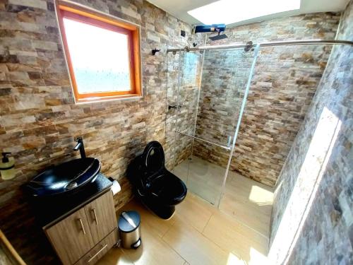 een badkamer met een douche en een glazen deur bij Bajo las estrellas deluxe in Ráquira