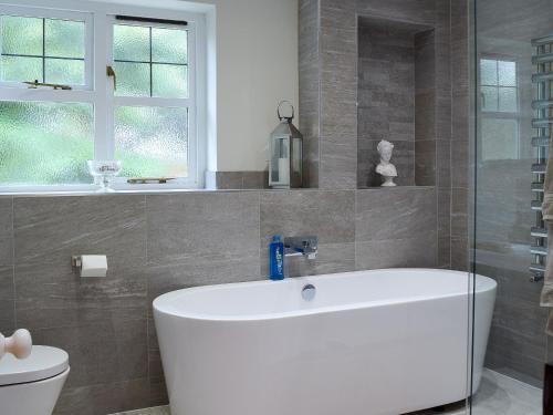 a bathroom with a white tub and a toilet at Little Lodge in West Mersea