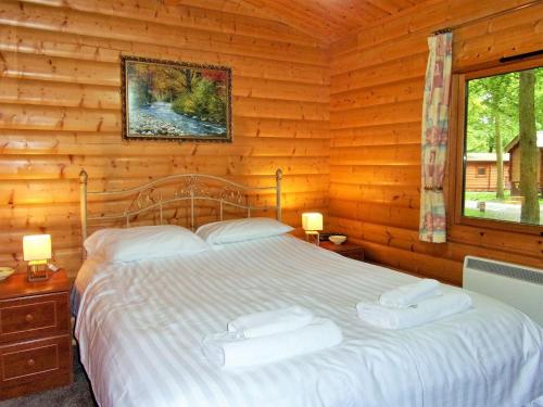 a bedroom with a bed in a log cabin at Haven Lodge in Legbourne
