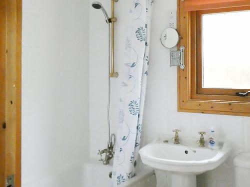 a bathroom with a sink and a shower curtain at Haven Lodge in Legbourne