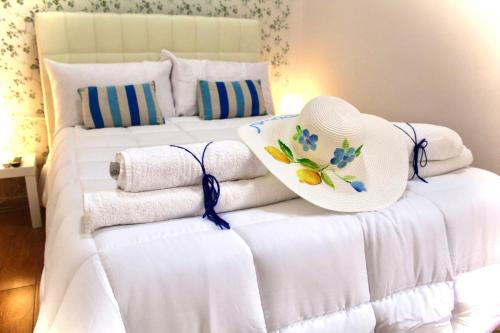 a white bed with towels and a hat on it at Street of Naples Apartment in Naples