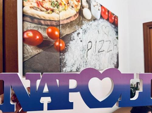 a sign with a picture of a pizza on it at Street of Naples Apartment in Naples