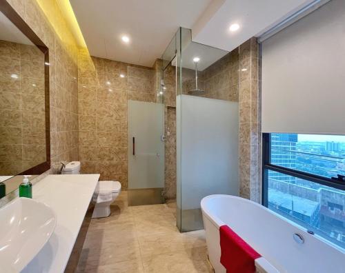 a bathroom with a tub and a toilet and a sink at Dorsett Residences Bukit Bintang in Kuala Lumpur