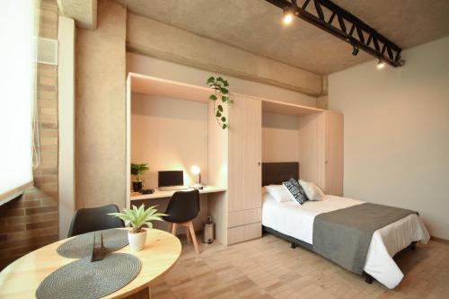 a bedroom with a bed and a table and a desk at Cadena Hotelera Rey es in Bogotá