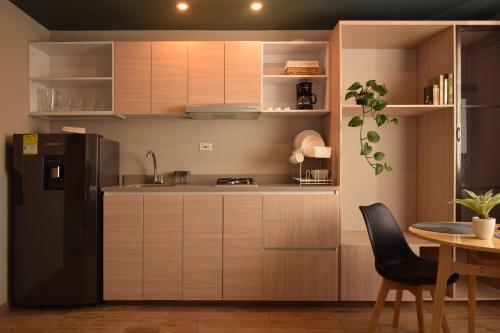 a kitchen with a black refrigerator and a table at Cadena Hotelera Rey es in Bogotá