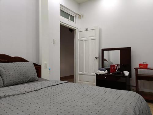 Schlafzimmer mit einem Bett, einem Spiegel und einer Tür in der Unterkunft Grey House in Da Lat