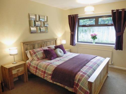 CortonにあるThe Beech Houseのベッドルーム1室(紫色の枕が付くベッド1台、窓付)