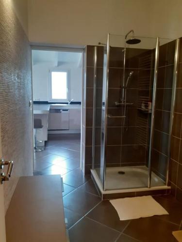 La salle de bains est pourvue d'une douche avec une porte en verre. dans l'établissement Le nid d'Aigle - proche Ajaccio, à Cuttoli-Corticchiato