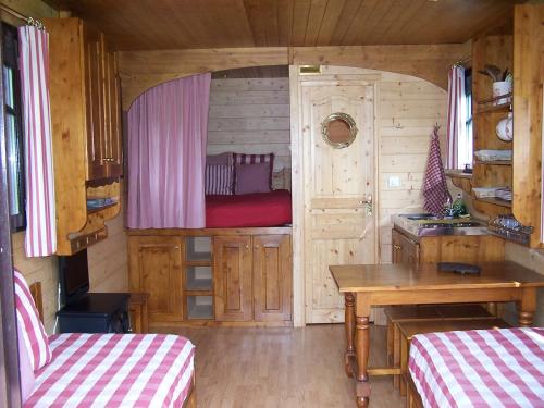 a cabin with a table and a bed in it at Les Roulottes de la Risle in Calleville