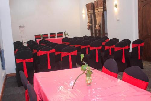 a room with red and black tables and chairs at King's Hill Hotel in Hatton