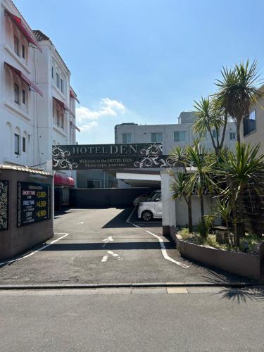 un parcheggio con un cartello per un hotel di ホテルDEN a Tokyo
