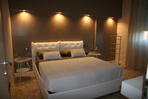 ミラノにあるChez Nousのベッドルーム1室(白い大型ベッド1台、テーブル2台付)