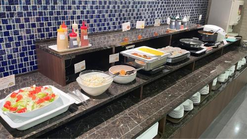 a buffet line with food on a table at Hotel Aston Plaza Kansai Airport in Izumi-Sano