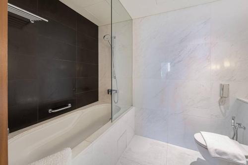 e bagno con vasca, servizi igienici e doccia. di Classy Studio at The Address Dubai Mall a Dubai