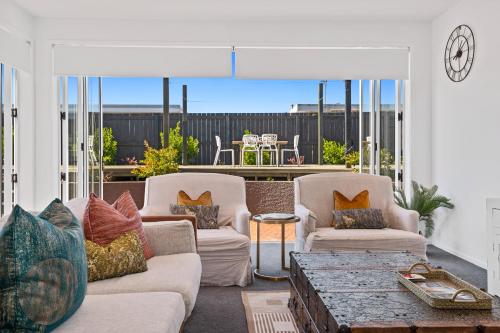 a living room with two couches and a table at Central Paradise Lodge II spa & Swimming pool in Rotorua