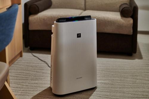 a white refrigerator sitting on the floor in front of a couch at The Royal Park Hotel Hiroshima Riverside in Hiroshima