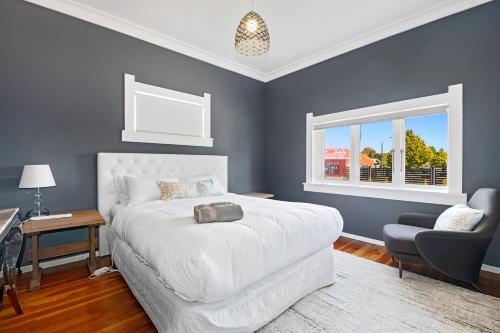 a bedroom with a bed and a chair and a window at Central Paradise Lodge II spa & Swimming pool in Rotorua